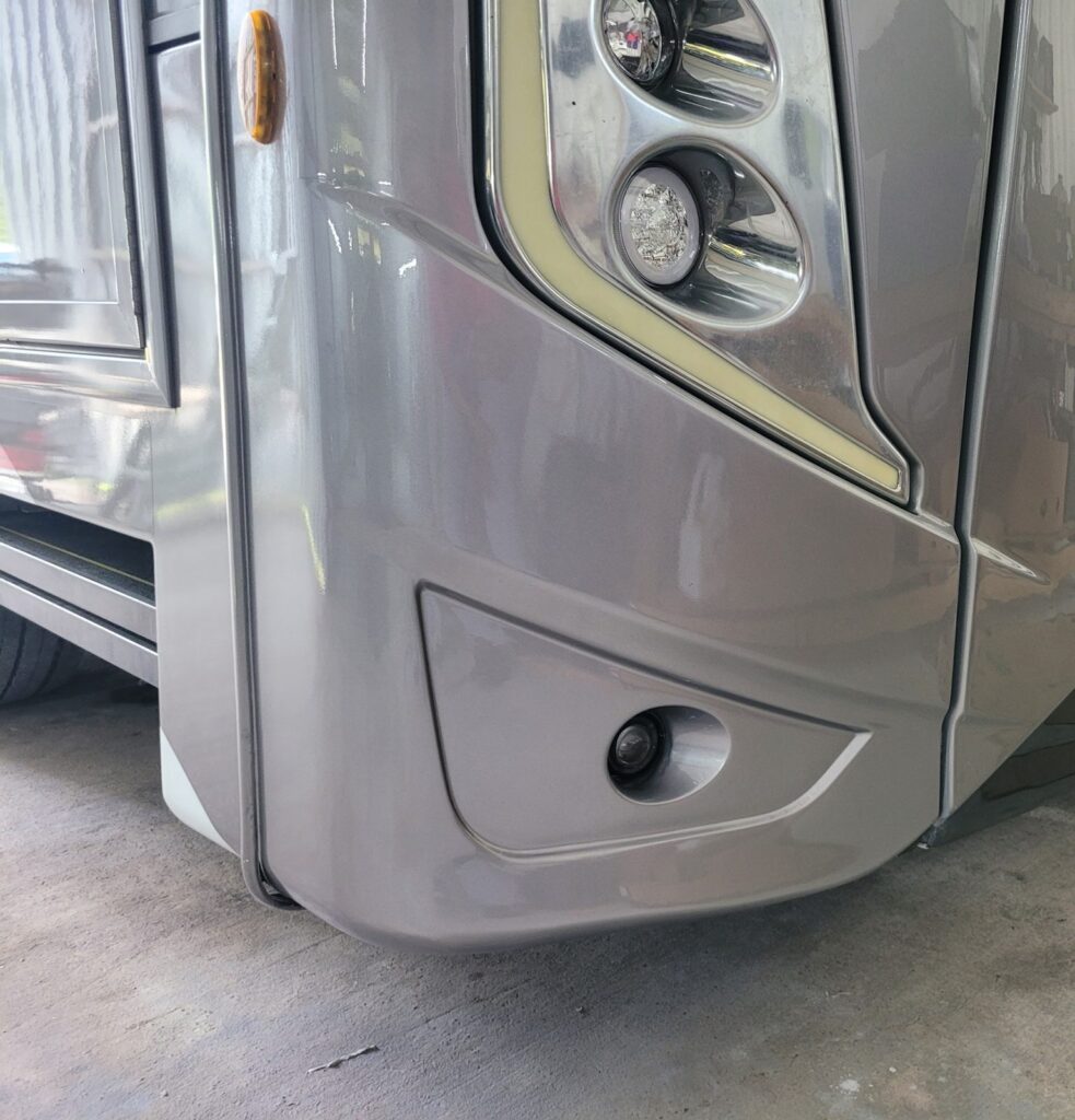 Motorhome front corner after fiberglass repair and paint The same motorhome front corner after fiberglass repair, paint and accent stripe restoration