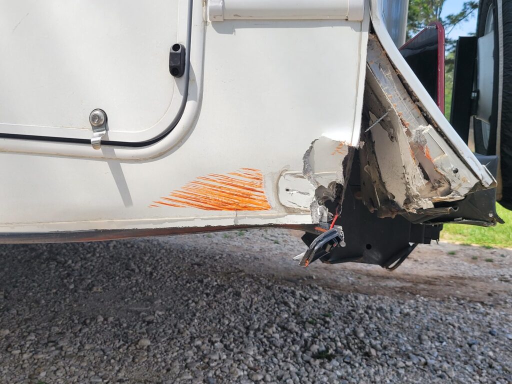 RV rear corner damage marked for an insurance claim Torn rear corner on an RV with estimator marks, before insurance claim repair